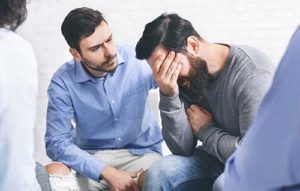 a man comforts another man during an lgbtq opioid detox program in southern california