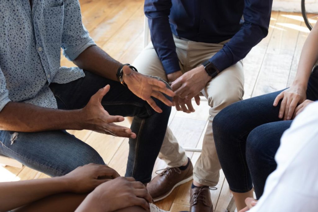 a group of hands in a circle during a meth addiction program