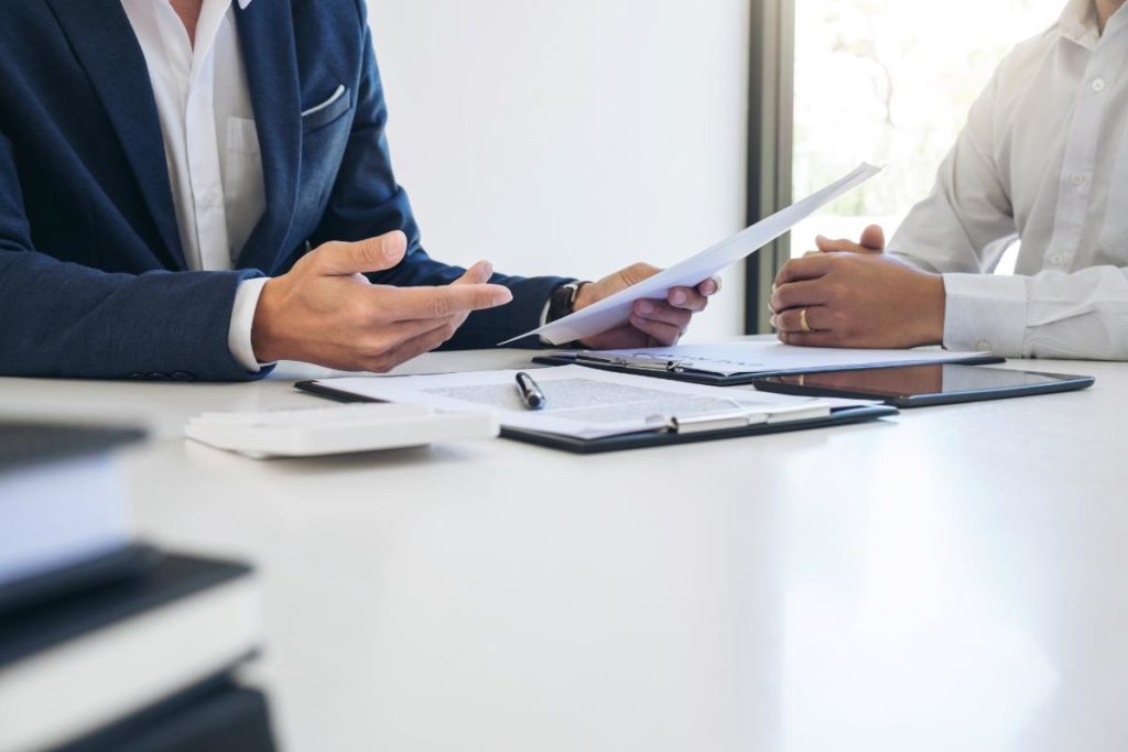 man in suit seated at desk with paperwork explaining the 5 benefits of choosing kaiser insurance