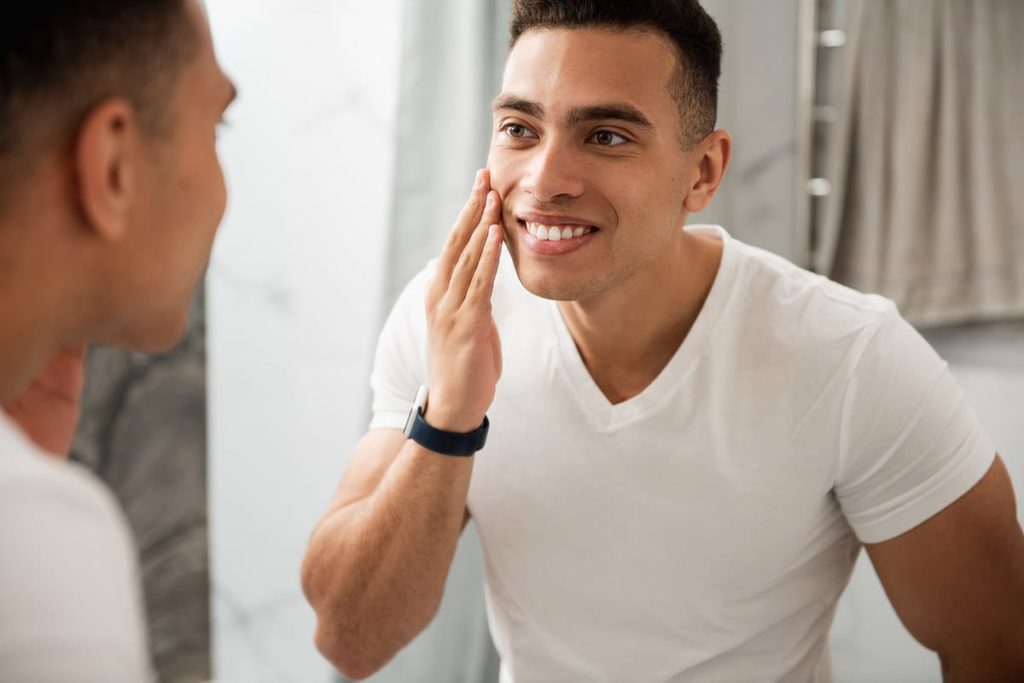 young healthy looking man studying himself in the mirror after learning how to quit meth safely and effectively