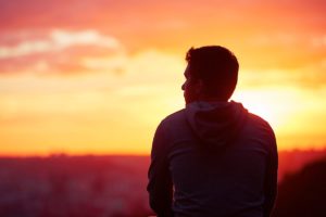 silhouette of a man looking into a sunset reflecting upon the dangers of mixing meth and alcohol