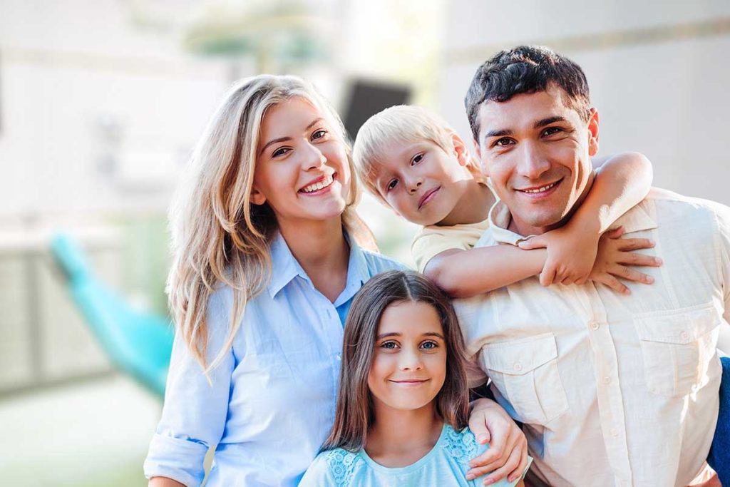 Family smiling and holding one another after family therapy