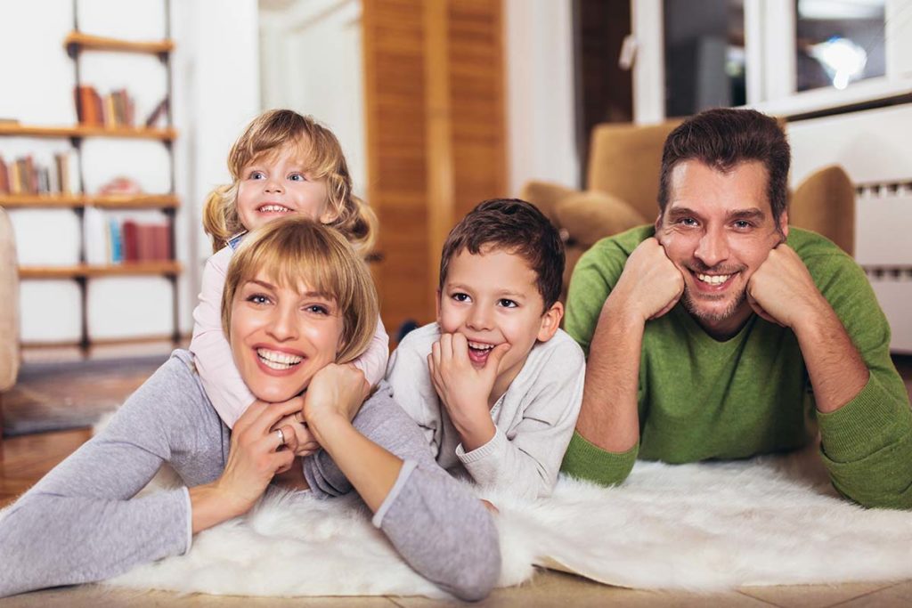 Family laying on ground smiling after family therapy