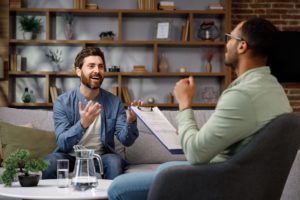 Man sitting on couch talking to therapist in dual diagnosis treatment