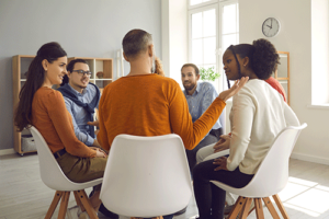 Young men and women participating in a group therapy session as part of a partial hospitalization program