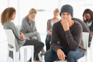 Person sitting in a waiting room, thinking about the benefits of ecstasy addiction rehab