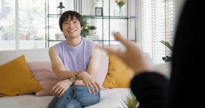 smiling young person engages in dialectical behavior therapy with an addiction treatment professional in an office setting