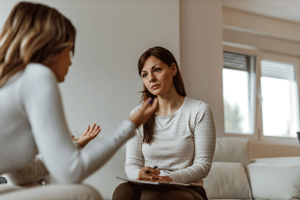 young, concerned woman discusses options for individual therapy programs with her therapist