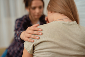 female therapist consoling a female patient as part of a PTSD treatment program