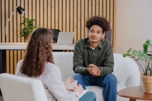 young man discussing the benefits of a painkiller rehab program with his behavioral health therapist