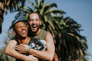 Gay couple hugging in front of palm tree