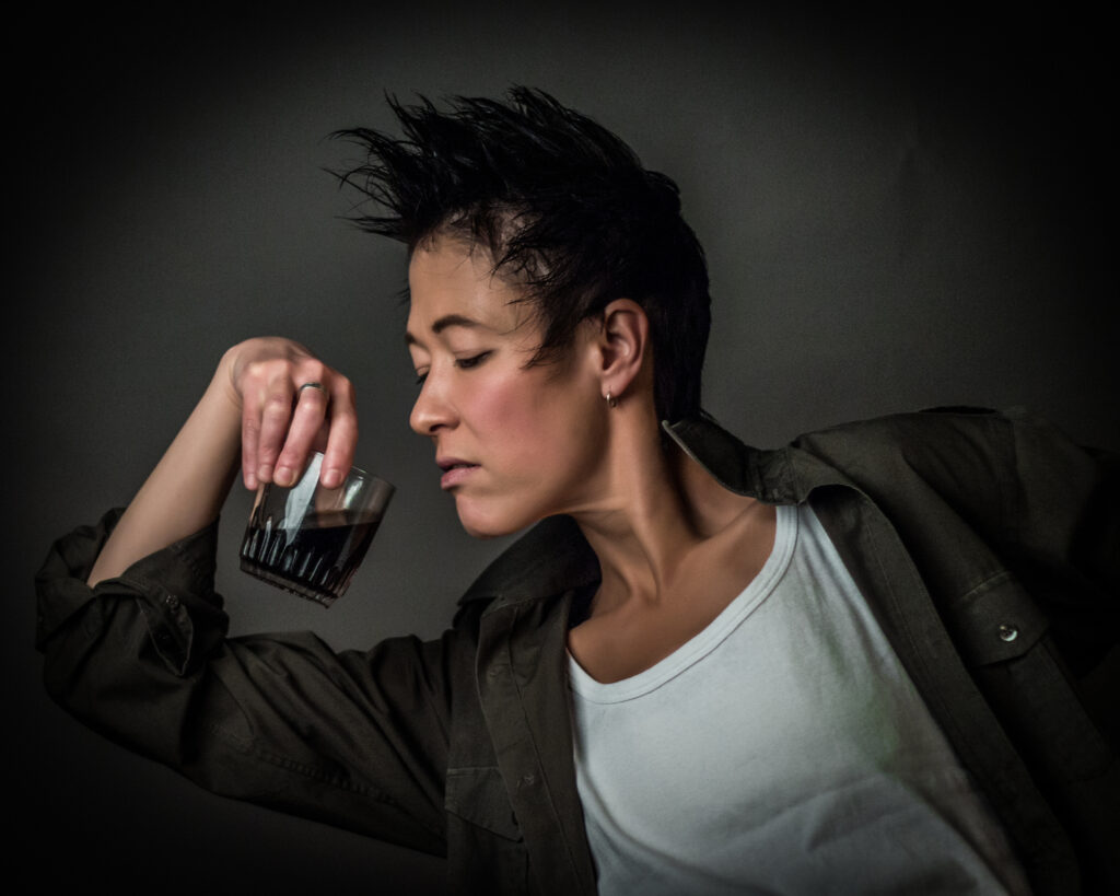 Androgynous person drinking alcohol