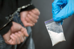 Man in handcuffs with bag of cocaine 